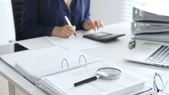 magnifying glass inspecting documents