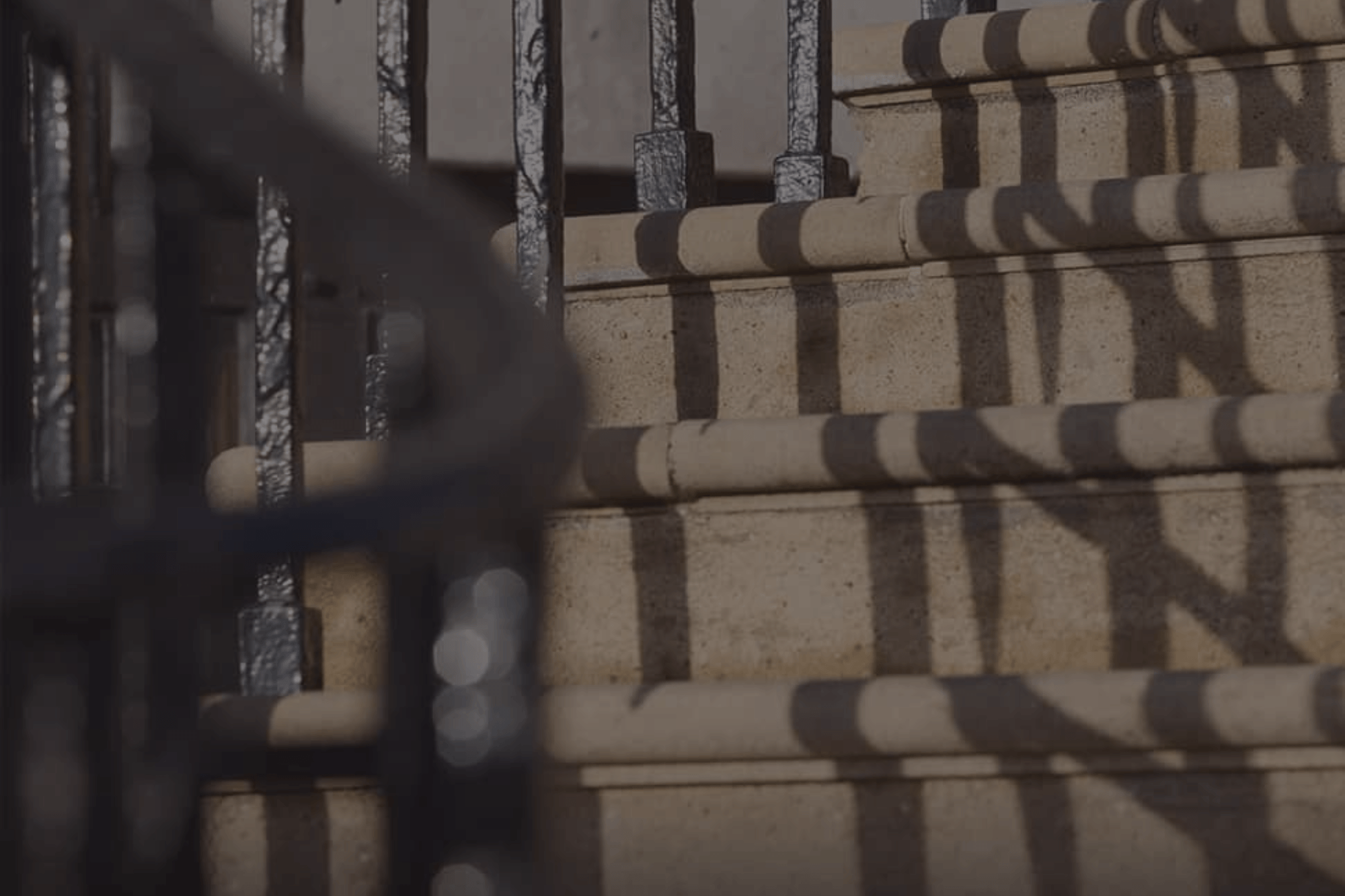 Stone steps outside Farrer & Co with black iron railings casting shadows