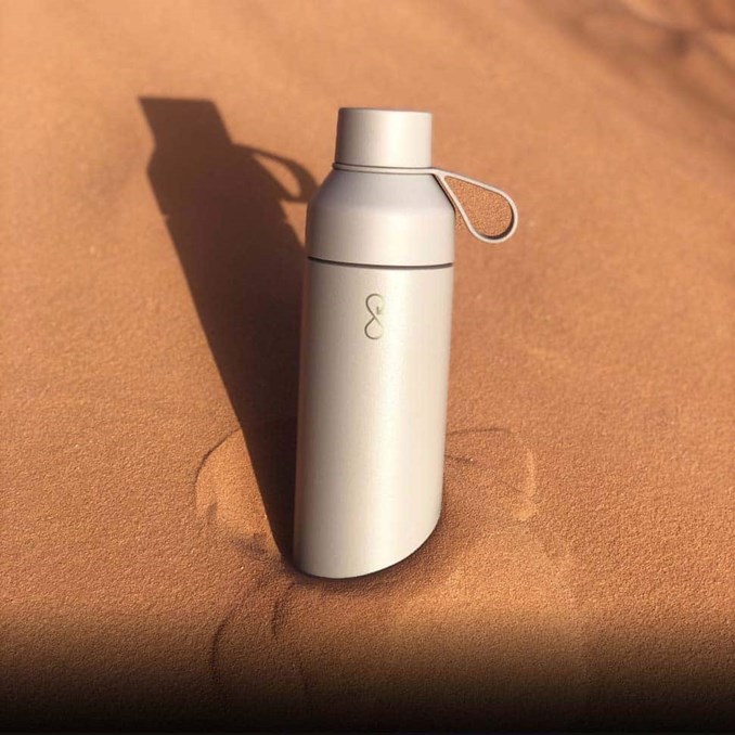 Ocean Bottle reusable water bottle on a sunlit stone surface