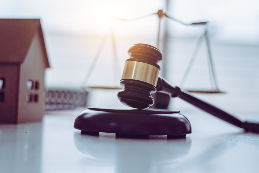Symbolic image of a model house beside legal scales and a gavel, representing disputes over wills and financial provision under the Inheritance (Provision for Family and Dependants) Act 1975.