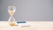 Hourglass beside calculator and coins illustrating business cashflow pressure and late payment deadlines