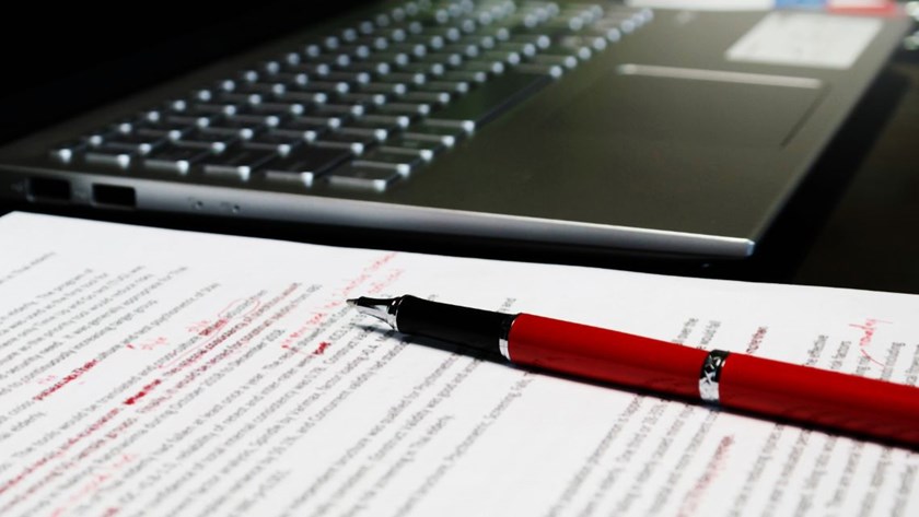 A blurred proofreading document on a table, symbolising the review and correction of errors in trust deeds.